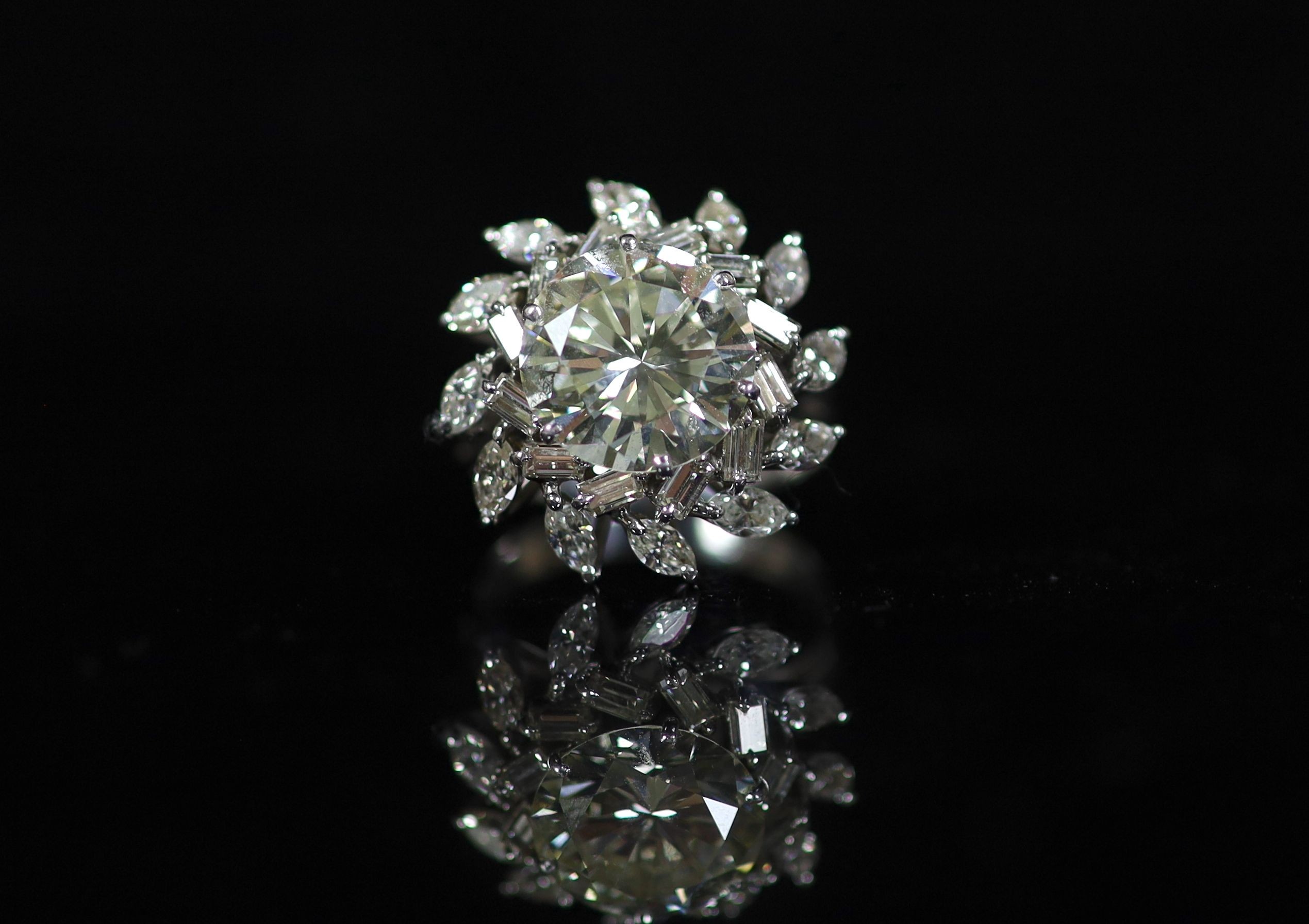 A platinum and single stone diamond ring, with baguette and marquise cut diamond foliate setting